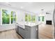 Bright kitchen with a farmhouse sink, modern faucet, and open view to living room at 1076 Williams Rd, Charleston, SC 29412