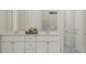 A clean, bright bathroom with double sinks, white cabinetry, and a tiled shower at 1130 Darling St, Summerville, SC 29485