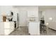 Bright, open kitchen with white cabinetry, stainless appliances, a breakfast bar, and wood flooring; connects to the living area at 1130 Darling St, Summerville, SC 29485