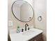 Modern bathroom featuring a round mirror, dark fixtures, a countertop, and stylish decor at 1166 Julian Clark Rd, Charleston, SC 29412