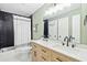 Bathroom with a dual-sink vanity, modern lighting, black herringbone tile, and shower at 1166 Julian Clark Rd, Charleston, SC 29412