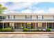 Inviting two-story townhome with a brick facade, cozy porch, and manicured landscaping at 1166 Julian Clark Rd, Charleston, SC 29412