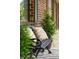 Inviting front porch detail featuring an iron bench, patterned pillows, and lush greenery at 1166 Julian Clark Rd, Charleston, SC 29412