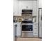 Close up view of modern stove, backsplash, cabinets and stainless steel refrigerator at 1166 Julian Clark Rd, Charleston, SC 29412