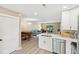An open-concept kitchen with stainless steel appliances views the living room and piano at 1166 Julian Clark Rd, Charleston, SC 29412