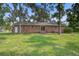 Expansive backyard featuring a well-maintained lawn, mature trees and a classic red brick home at 127 Cornell Dr, Ladson, SC 29456
