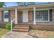 Close up of the charming brick home's front porch with white door, columns, and brick stairs at 127 Cornell Dr, Ladson, SC 29456
