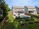 A spacious backyard featuring a refreshing pool, raised garden beds, lush greenery, and a charming screened-in porch at 1825 Crossbill Trl, Hanahan, SC 29410