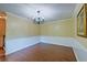 Empty dining room showing wainscoting, a chandelier, and wood floors at 202 Hunt Club Dr, Summerville, SC 29485