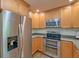 Close up of stainless steel appliances with granite countertops and wood cabinets at 202 Hunt Club Dr, Summerville, SC 29485