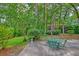 Inviting backyard patio with outdoor seating, lush landscaping, and a tranquil, wooded backdrop at 202 Hunt Club Dr, Summerville, SC 29485