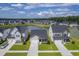 Aerial view of homes in a community with a pond, showcasing neighborhood layout and green spaces at 206 Camellia Bloom Dr, Moncks Corner, SC 29461