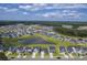 Panoramic aerial view of a community featuring a pond surrounded by homes and wooded areas at 206 Camellia Bloom Dr, Moncks Corner, SC 29461