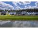 A picturesque view of homes with a beautiful lawn stretching down to a serene pond at 206 Camellia Bloom Dr, Moncks Corner, SC 29461
