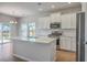 Bright kitchen features white cabinets, quartz countertops, stainless steel appliances, and a large island at 206 Camellia Bloom Dr, Moncks Corner, SC 29461