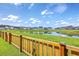 Scenic pond view from a backyard enclosed by a rustic wooden fence at 206 Camellia Bloom Dr, Moncks Corner, SC 29461