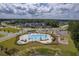 Aerial view of a community pool with ample seating, umbrellas, parking, and a playground nearby at 206 Camellia Bloom Dr, Moncks Corner, SC 29461