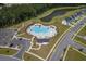 Aerial view of a community pool with ample seating, umbrellas, parking, and a playground nearby at 206 Camellia Bloom Dr, Moncks Corner, SC 29461