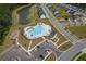 Aerial view of a community pool with ample seating, umbrellas, parking, and a playground nearby at 206 Camellia Bloom Dr, Moncks Corner, SC 29461