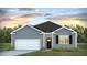 Charming single-story home with a gray exterior, a white garage door, and a well-manicured lawn in a peaceful neighborhood at 2140 Macallan Blvd, Ravenel, SC 29470