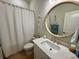 Nautical themed bathroom with a round mirror and a shower with curtain at 2221 Generals St, Charleston, SC 29492