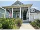 Charming home with a spacious front porch adorned with potted plants and an American flag at 2221 Generals St, Charleston, SC 29492
