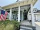 Inviting front porch decorated with flower pots and a flag, enhancing the curb appeal of this home at 2221 Generals St, Charleston, SC 29492