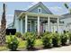Inviting home showcasing blue siding, white trim, a welcoming front porch with rocking chairs, and a two-car garage at 2221 Generals St, Charleston, SC 29492