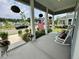 Charming front porch featuring hanging plants, rocking chairs, and an American flag at 2221 Generals St, Charleston, SC 29492