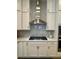 Modern kitchen showcasing stainless steel vent hood, white cabinets, and subway tile backsplash at 2221 Generals St, Charleston, SC 29492