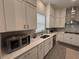 Kitchen with white cabinets, modern appliances, and gray backsplash at 2221 Generals St, Charleston, SC 29492