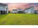 Spacious backyard showing lush green grass and view of the back of the home with a screened in porch at 223 Granton Edge Ln, Summerville, SC 29486