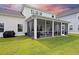Expansive backyard features lush green grass and a screened porch perfect for relaxing and enjoying the outdoors at 223 Granton Edge Ln, Summerville, SC 29486