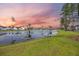 Scenic pond with lush green shoreline and a backdrop of houses nestled among trees under a colorful sky at 223 Granton Edge Ln, Summerville, SC 29486