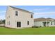 Grassy backyard with contemporary home, featuring a sliding glass door and well-manicured landscaping for outdoor enjoyment at 2242 Macallan Blvd, Ravenel, SC 29470