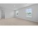 A light-filled bedroom with neutral carpeting and a view of the neighborhood through bright, sunny windows at 2242 Macallan Blvd, Ravenel, SC 29470