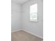 A walk-in closet with neutral carpeting, wire shelving, and natural light from a window to keep clothing organized at 2242 Macallan Blvd, Ravenel, SC 29470