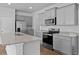 Kitchen features a granite countertop island, stainless steel appliances, and gray cabinets at 2242 Macallan Blvd, Ravenel, SC 29470