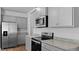 Close up of the kitchen area features stainless steel appliances and gray cabinets at 2242 Macallan Blvd, Ravenel, SC 29470