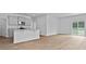 Open-concept living area with a modern kitchen and sliding glass doors to the lake at 2242 Macallan Blvd, Ravenel, SC 29470