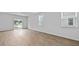 Bright living room showcasing wood floors and natural light from a sliding glass door at 2242 Macallan Blvd, Ravenel, SC 29470