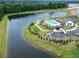 Aerial view showcasing community amenities: pool, clubhouse, putting green, and surrounding lake and trees at 256 Fiddleback Dr, Summerville, SC 29486