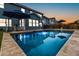 Beautiful backyard pool and home at sunset, surrounded by stone patio and an outdoor dining area at 256 Fiddleback Dr, Summerville, SC 29486