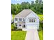Aerial view of a charming two-story home with blue siding, shutters, a well-kept lawn, and an attached garage at 256 Fiddleback Dr, Summerville, SC 29486
