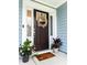 Close-up of a front door adorned with a wreath, surrounded by potted plants at 256 Fiddleback Dr, Summerville, SC 29486