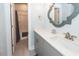 The bathroom features a white countertop, grey cabinets, a decorative mirror, and a shower with a curtain at 2734 Battle Trail Dr, Johns Island, SC 29455