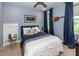 Bedroom with blue walls, a large bed, guitar wall decor, and a window with natural light at 2734 Battle Trail Dr, Johns Island, SC 29455
