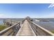 Picturesque community pier extending into the water with benches and covered areas for relaxation at 2734 Battle Trail Dr, Johns Island, SC 29455