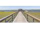 Picturesque community pier extending into the water with benches and covered areas for relaxation at 2734 Battle Trail Dr, Johns Island, SC 29455