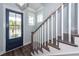 Bright entryway with a dark blue front door and stairs with white risers and a wood handrail at 2734 Battle Trail Dr, Johns Island, SC 29455